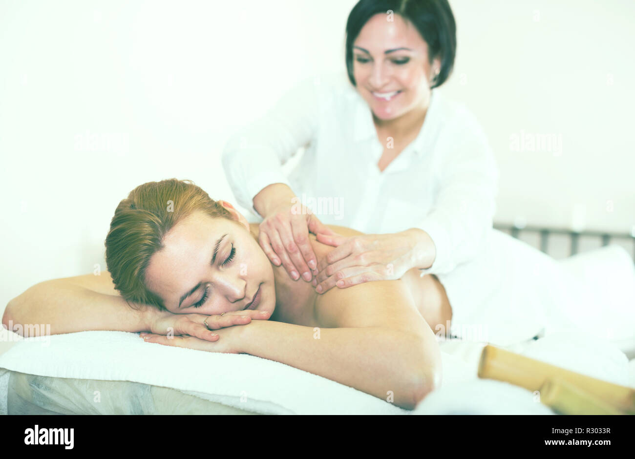 https://c8.alamy.com/comp/R3033R/adult-masseuse-massaging-shoulders-and-neck-of-young-woman-in-massage-salon-R3033R.jpg