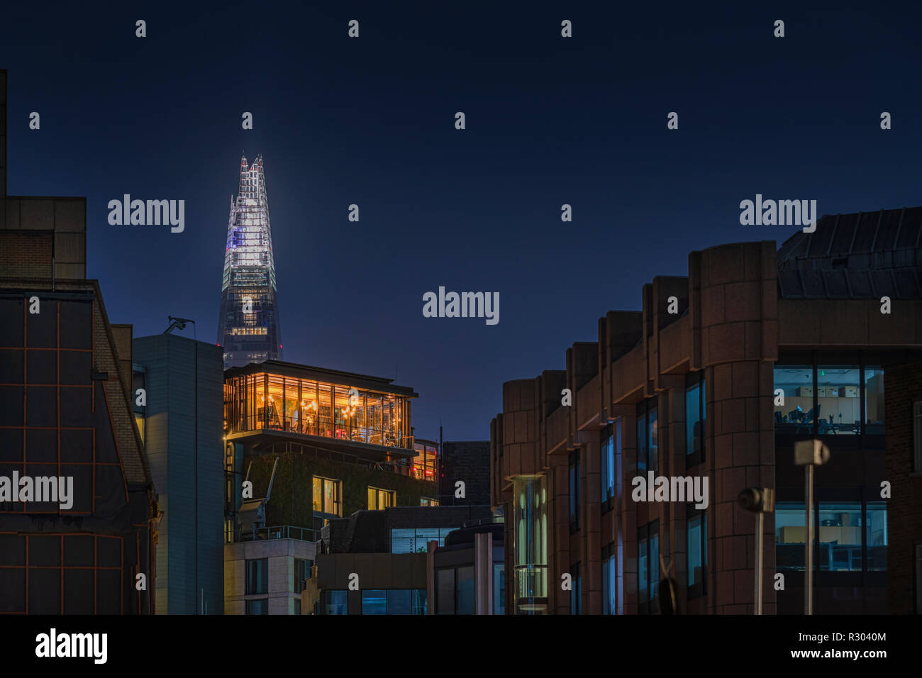 View of The Shard at night from Jewry Street with a hotel bar and Friary Court in the foreground Stock Photo