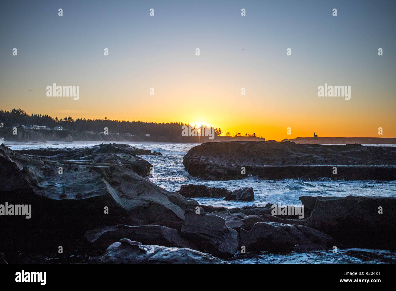 Sunset Bay State Park lives up to it's name as the setting sun casts a gentle glow over low tide. Stock Photo