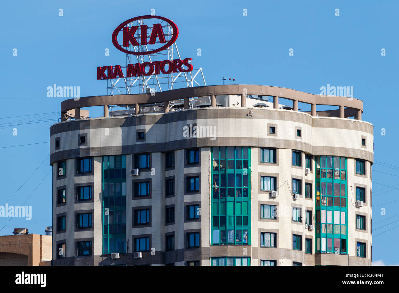 Kia Motors advertising sign, illumunated at night, on top of an apartment block in Moscow, Russia. Adjacent to the Moscow canal. Stock Photo
