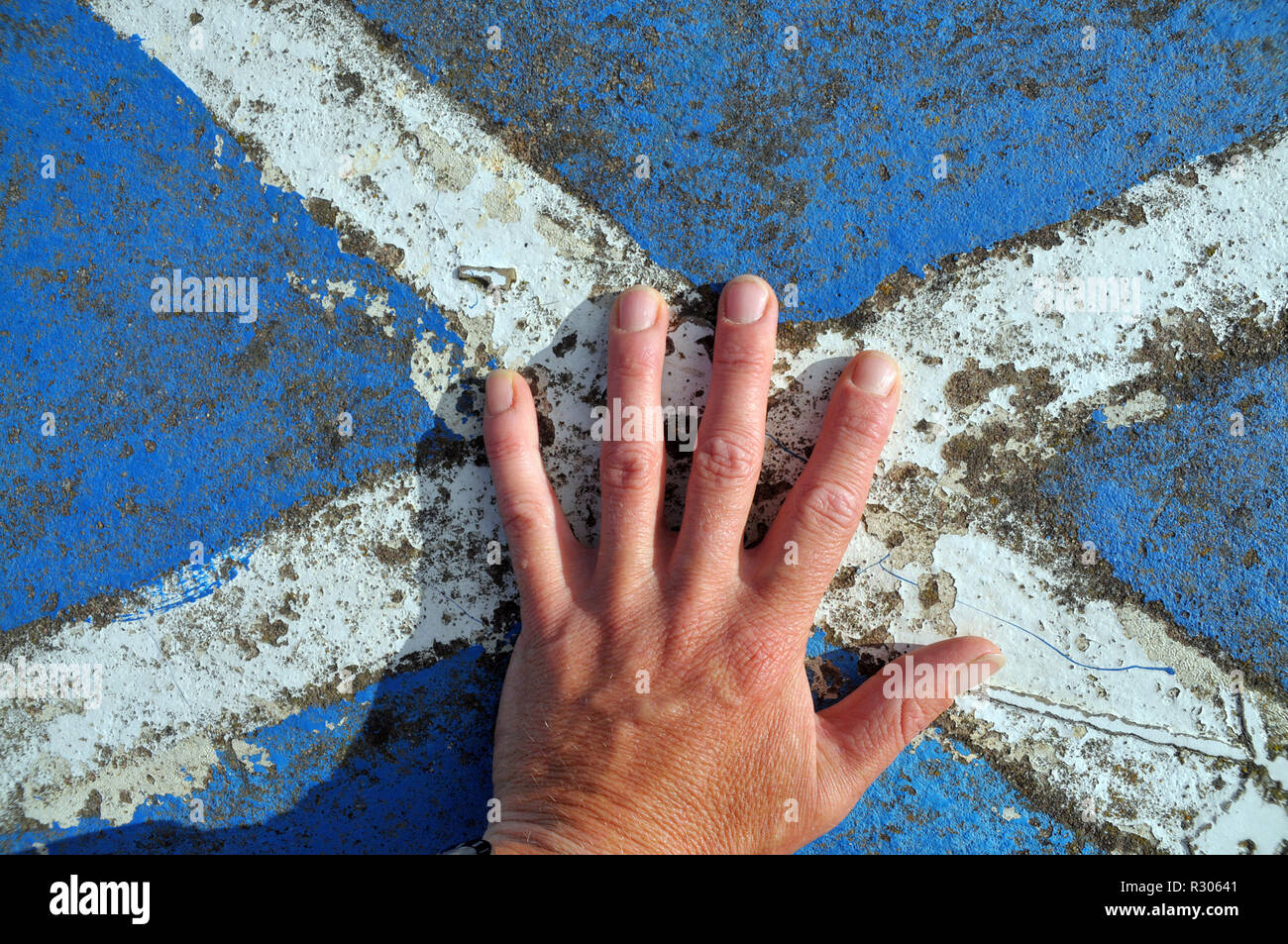 hand on Scottish flag, the saltire - painted on rock Stock Photo