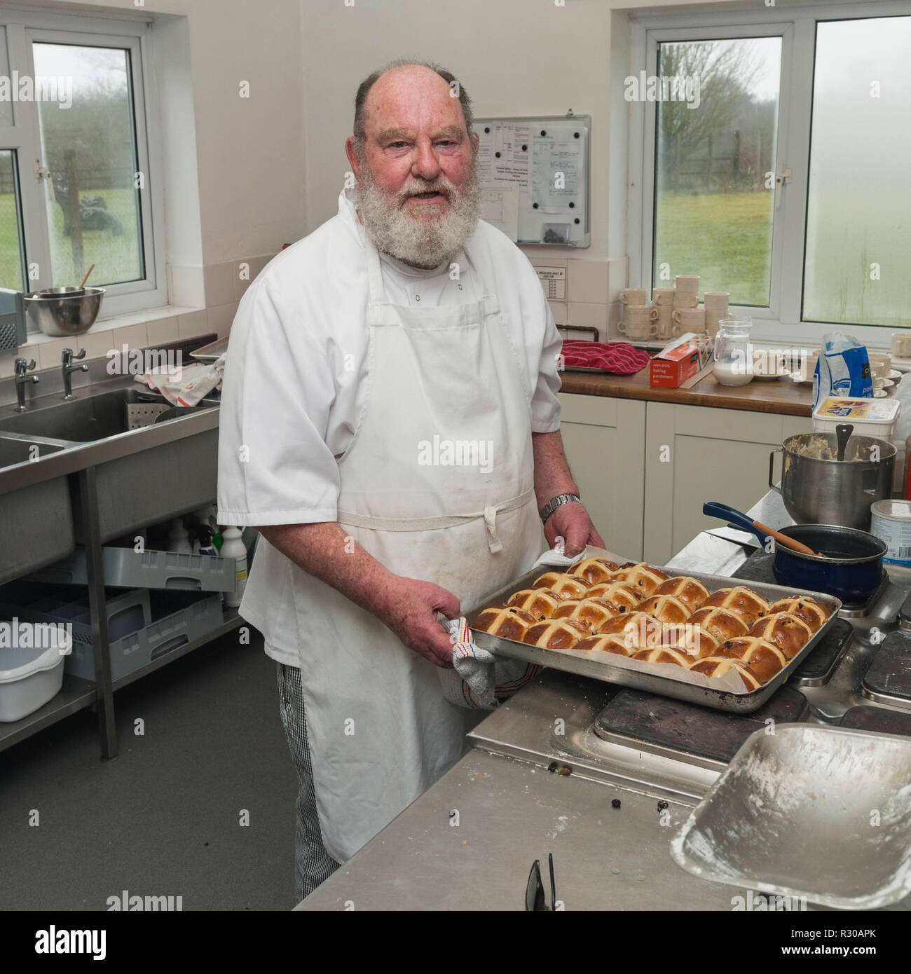 A retired chef cooking hot cross buns in the Uk Stock Photo