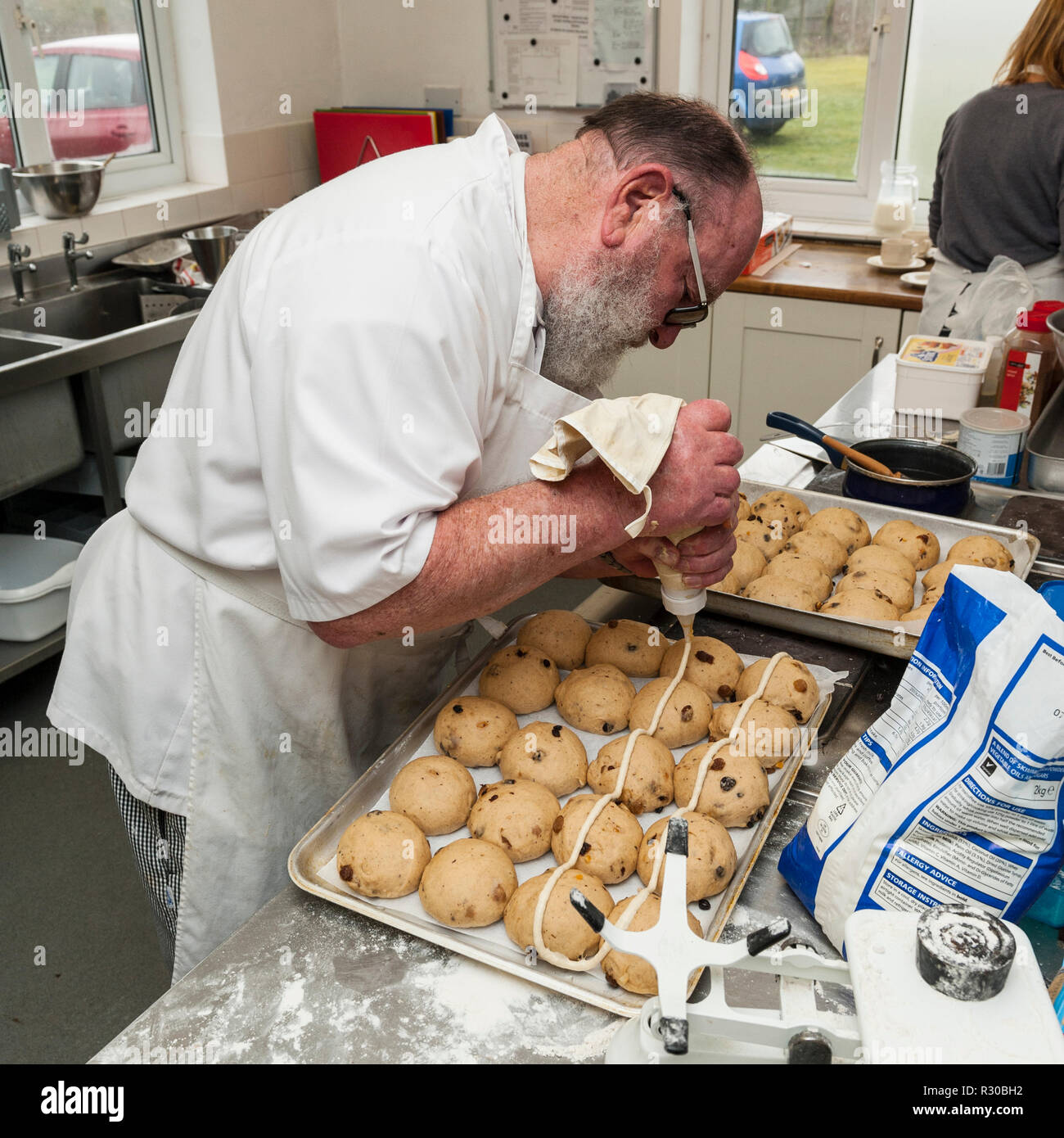 A retired chef cooking hot cross buns in the Uk Stock Photo