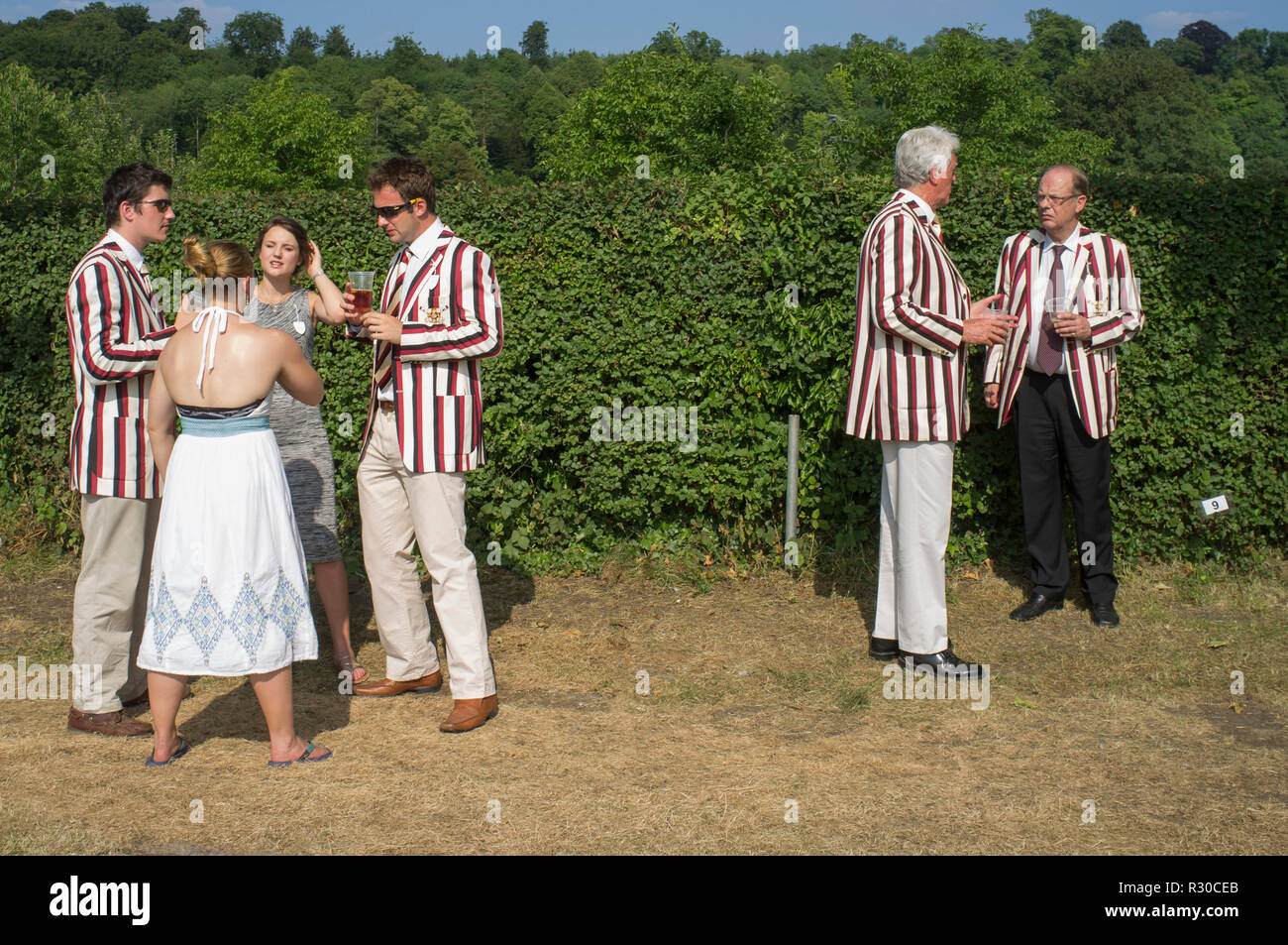 A party wearing red, white and black striped rowing blazers Henley Royal Regatta, Henley-on-Thames, Oxfordshire Stock Photo