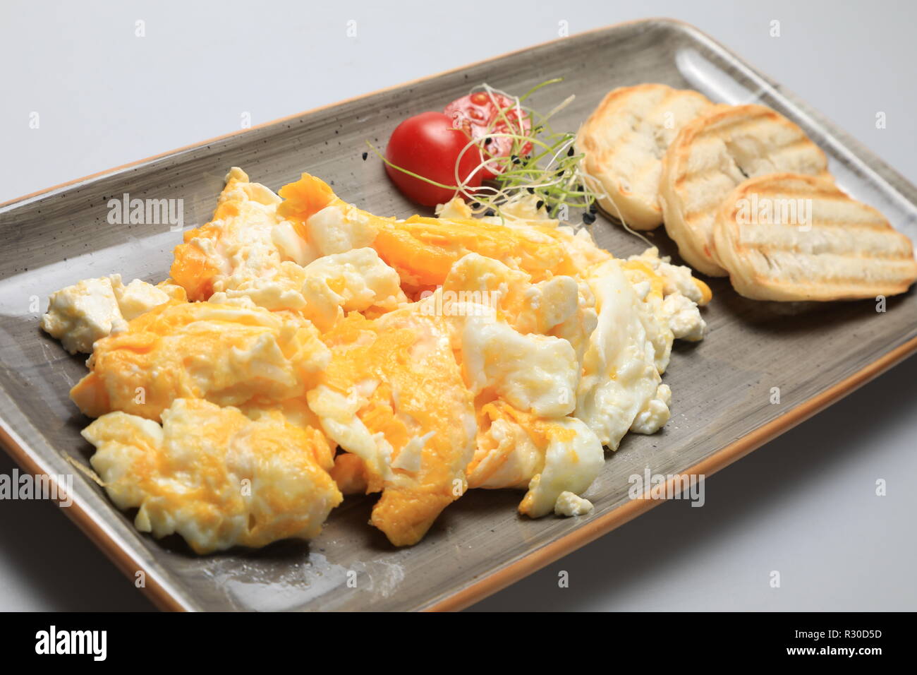 Scrambled eggs wioth some bread and cherry tomatoes Stock Photo