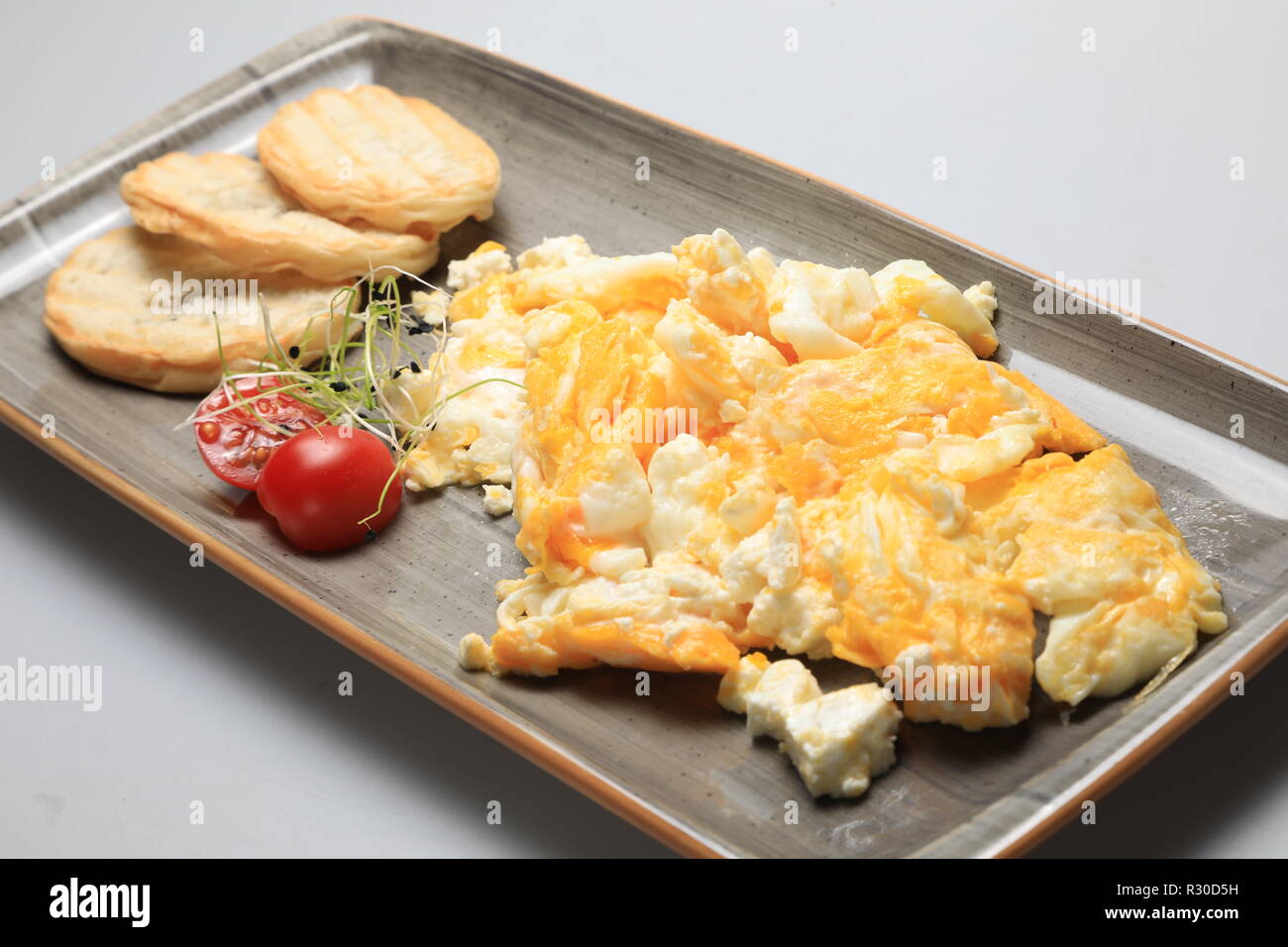 Scrambled eggs wioth some bread and cherry tomatoes Stock Photo