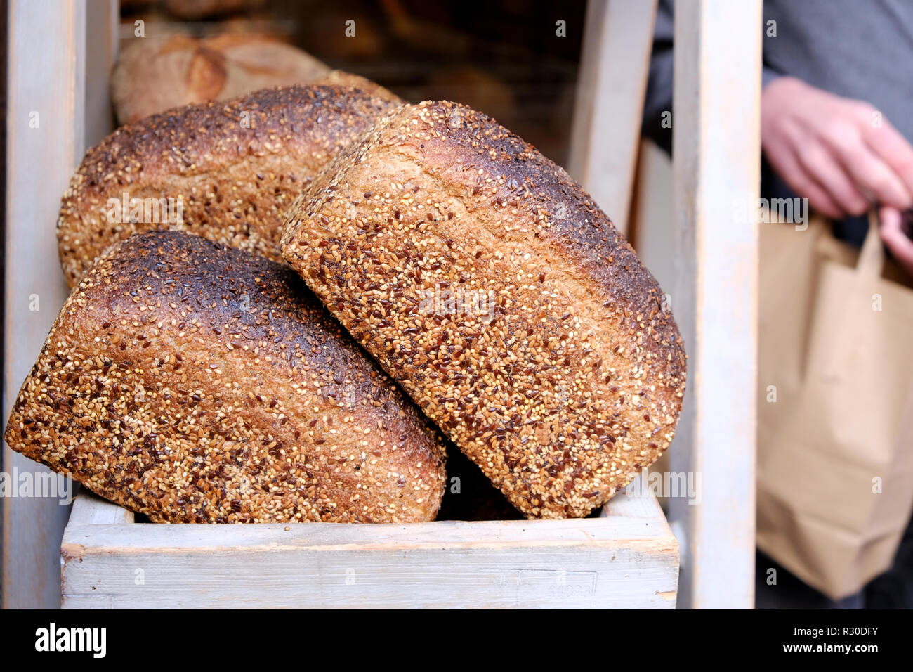 Freshly cooked brown seeded farmhouse loaves of bread for sale outside of an artesian bakery in Birmingham, UK Stock Photo