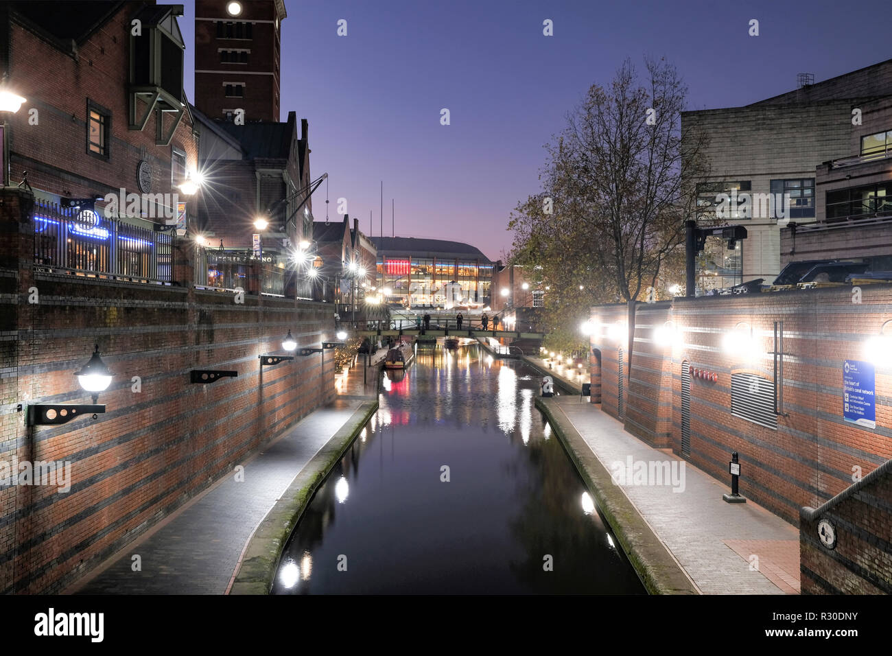 A night time, shot of the Old Main Line canal in Birmingham city center as it passes through Brindley Place. the area is illuminated with street light Stock Photo