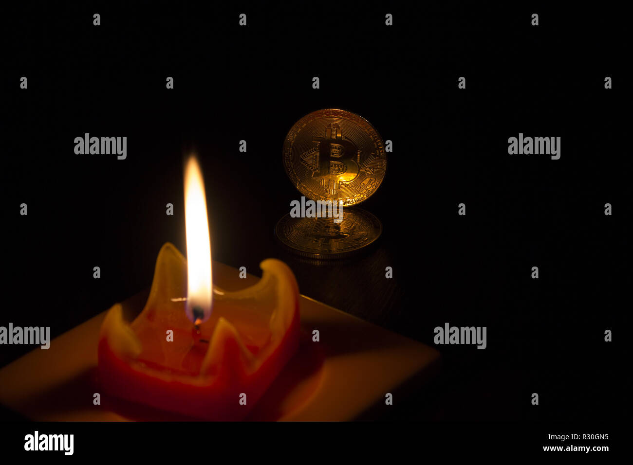 The red candle illuminates the gold crypto curency coins bitcoin and