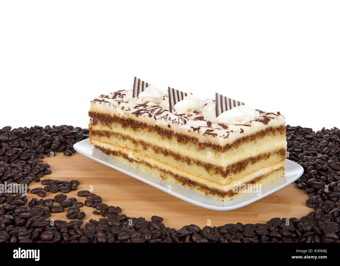 Tiramisu on a rectangular plate on wood table isolated on white
