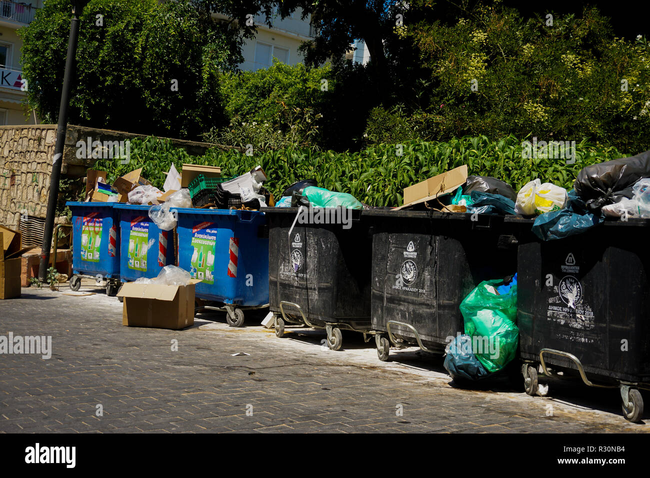 Large recycling and landfill bins on the side of a street in Heraklion, Crete. Stock Photo