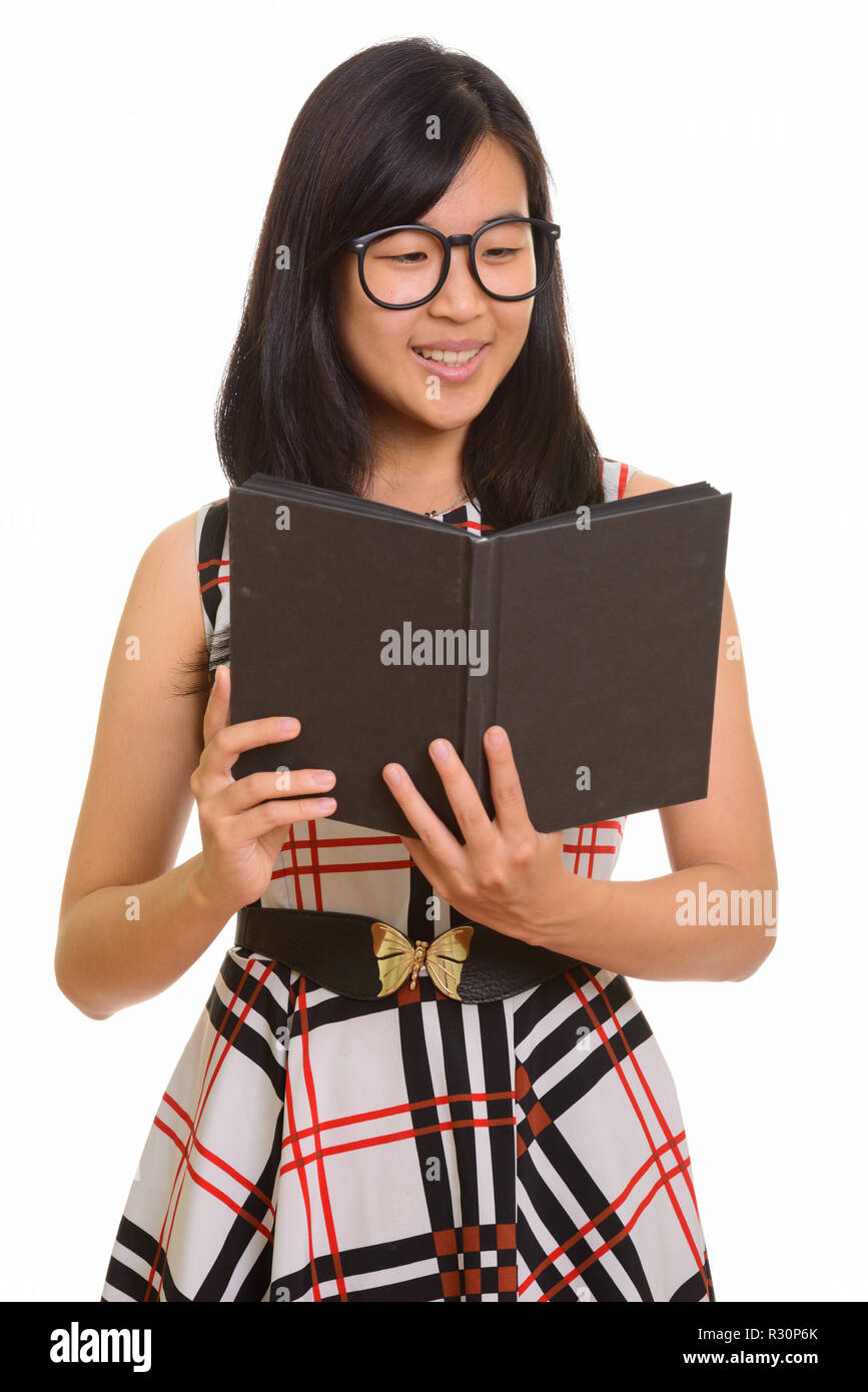 Young happy Asian businesswoman smiling and reading book Stock Photo