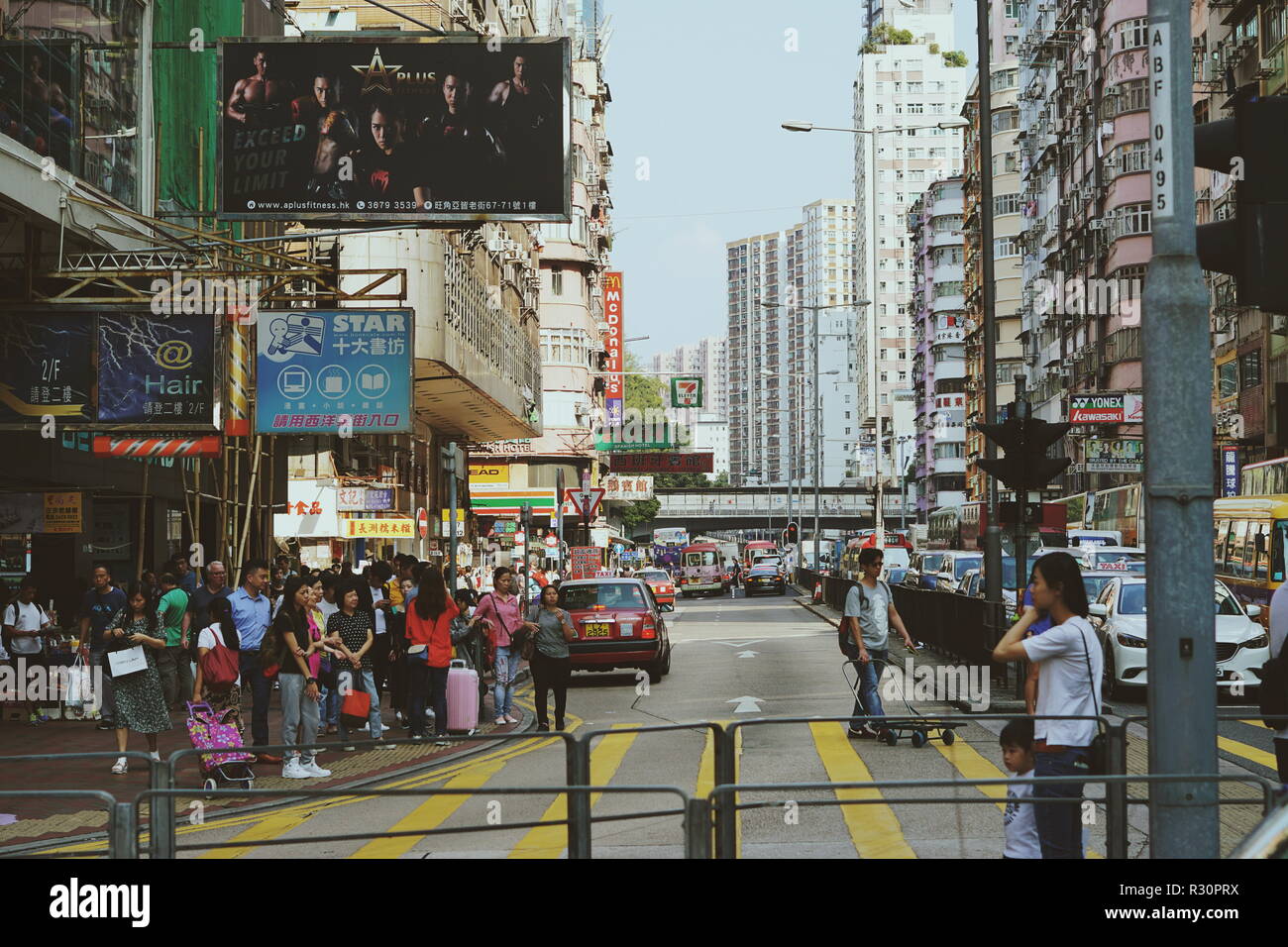 People wait to cross a busy street in Hong Kong Stock Photo