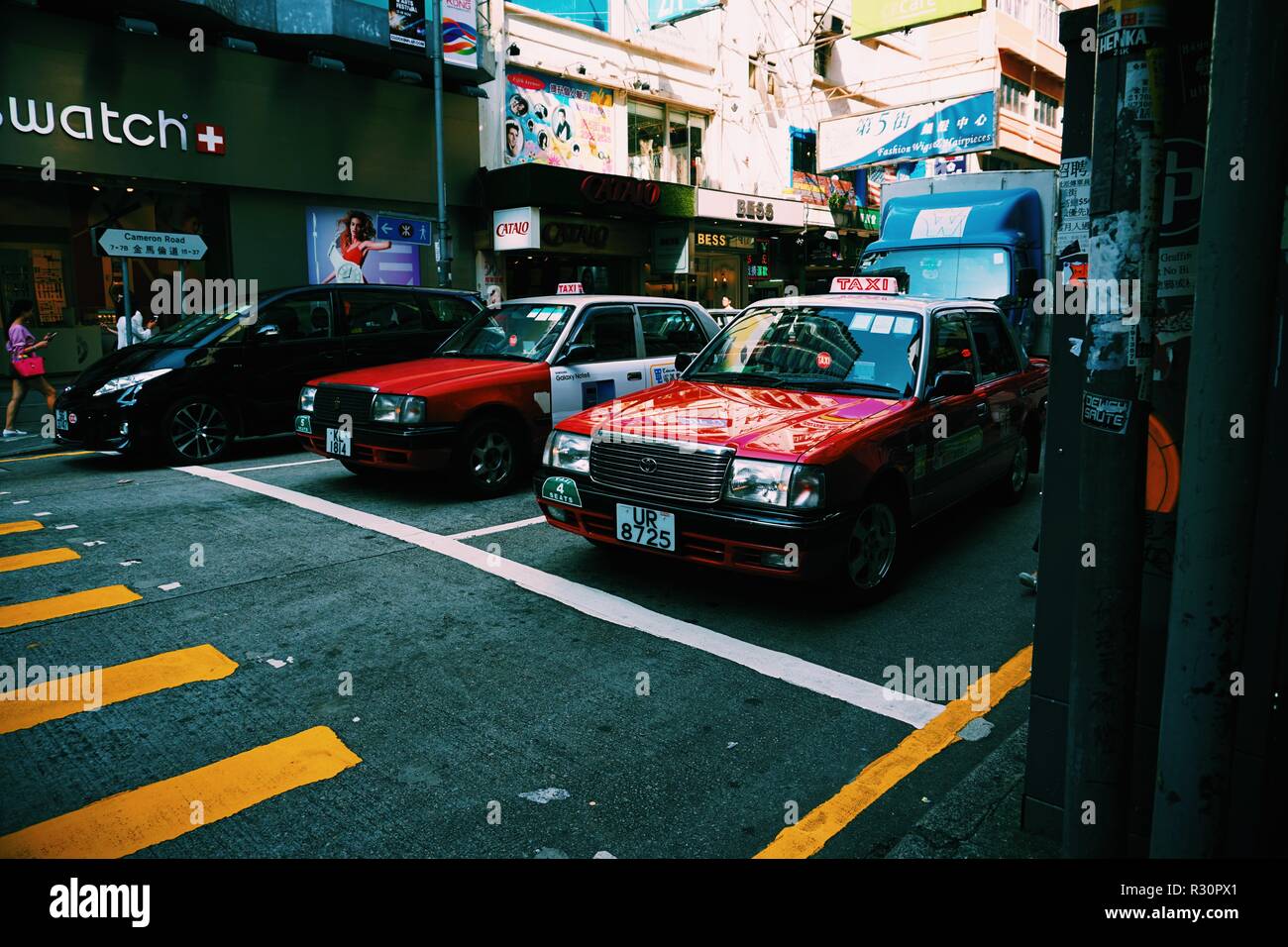Taxis wait at traffic lights in Tsim Sha Tsui, Hong Kong. Stock Photo