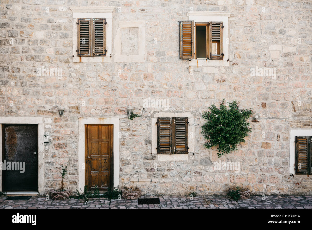 The facade of an ordinary old building with a door and windows in Montenegro. Traditional housing. Stock Photo