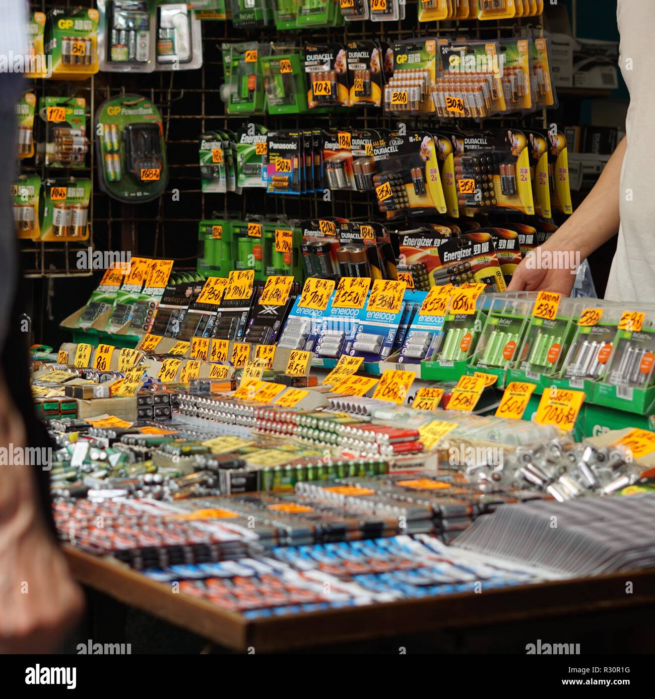 Man selling a variety of batteries at a market. Sham Shui Po, Hong Kong. Stock Photo