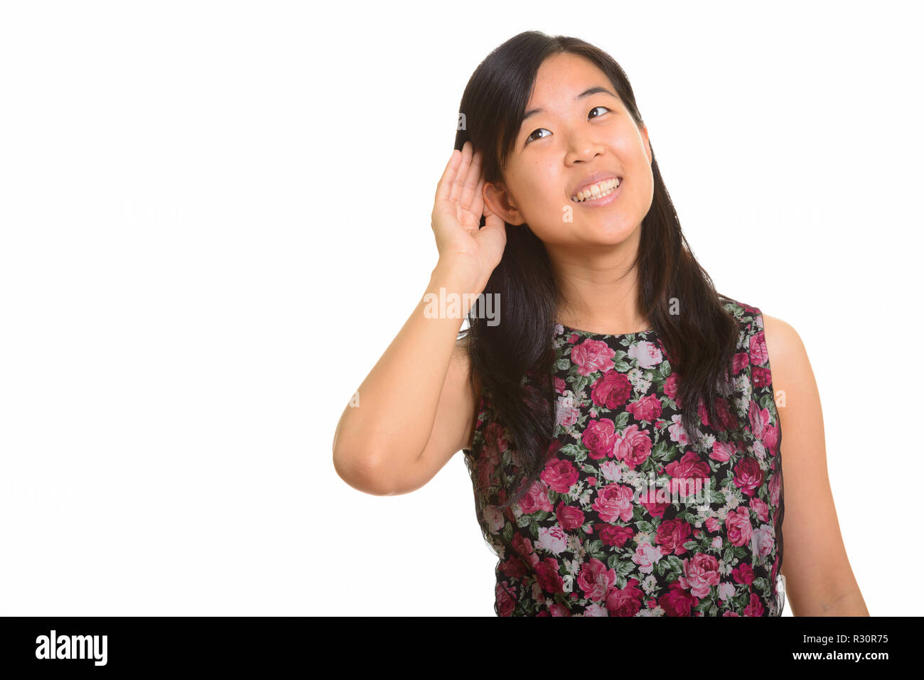 Portrait of young happy Asian woman listening Stock Photo