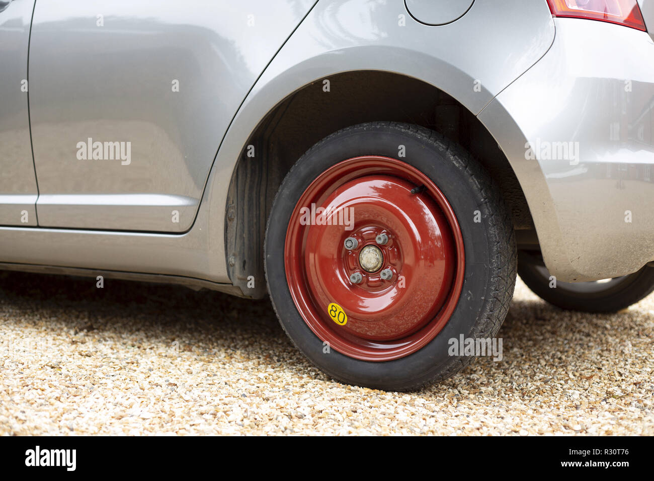 Space saver wheel and spare tyre or tire fitted to a small car Stock Photo