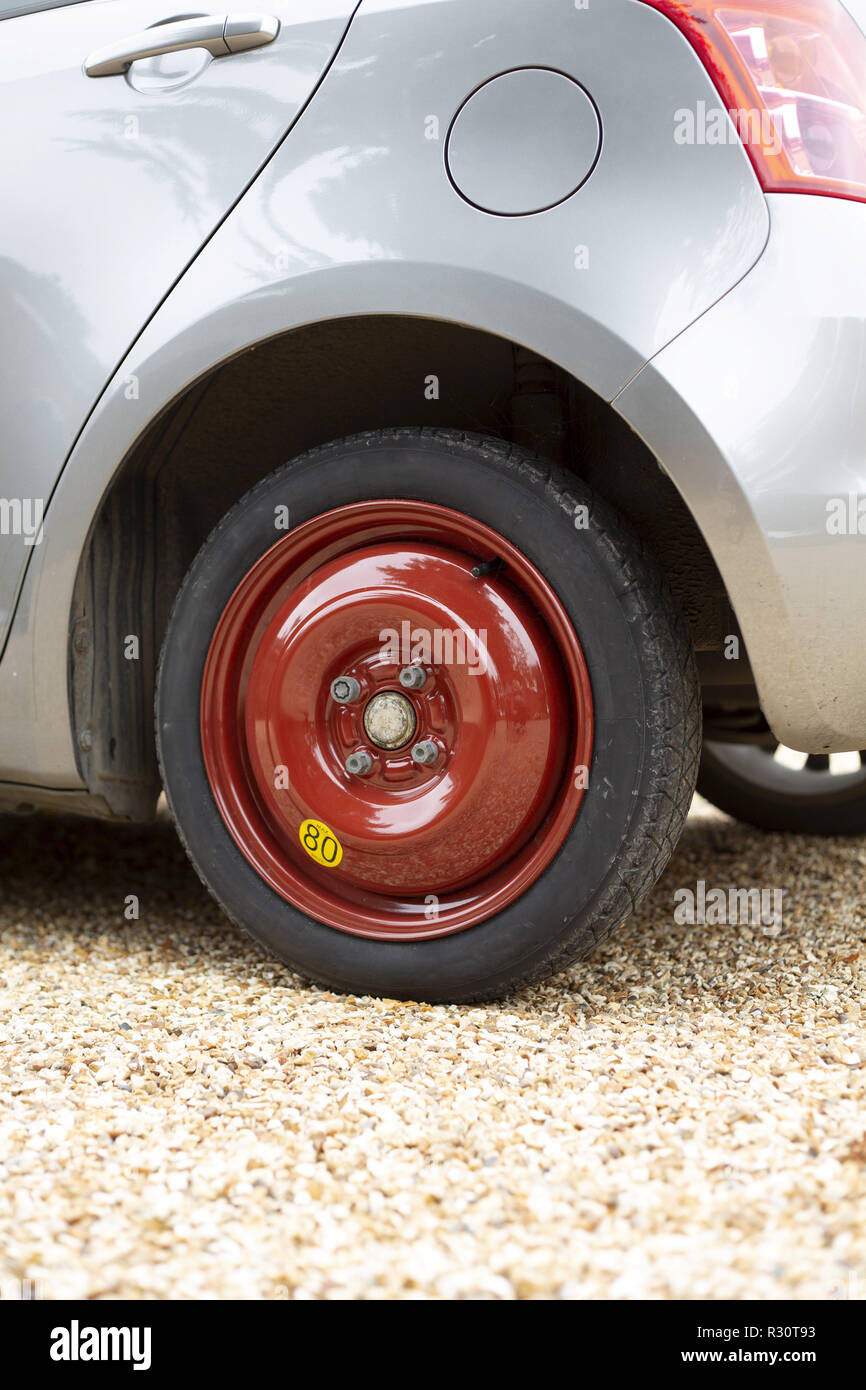 Small car fitted with a spare tyre or tire on a space saver wheel Stock Photo