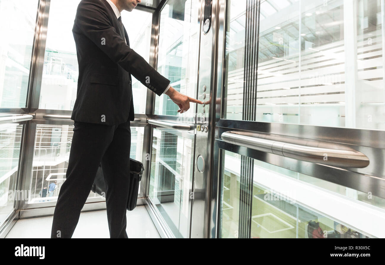 Man pressing elevator button. finger presses elevator button. businessman in lift Stock Photo