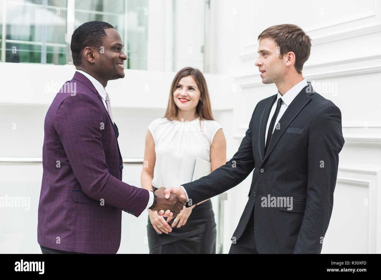 two young businessmen shake hands Stock Photo