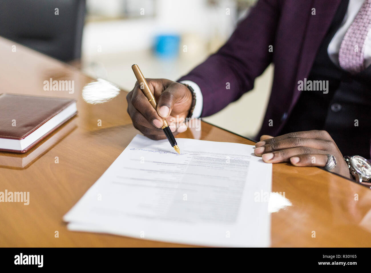 https://c8.alamy.com/comp/R30Y65/african-american-man-signing-contract-black-man-hand-putting-signature-on-official-document-biracial-clients-customers-couple-make-purchase-or-sign-R30Y65.jpg