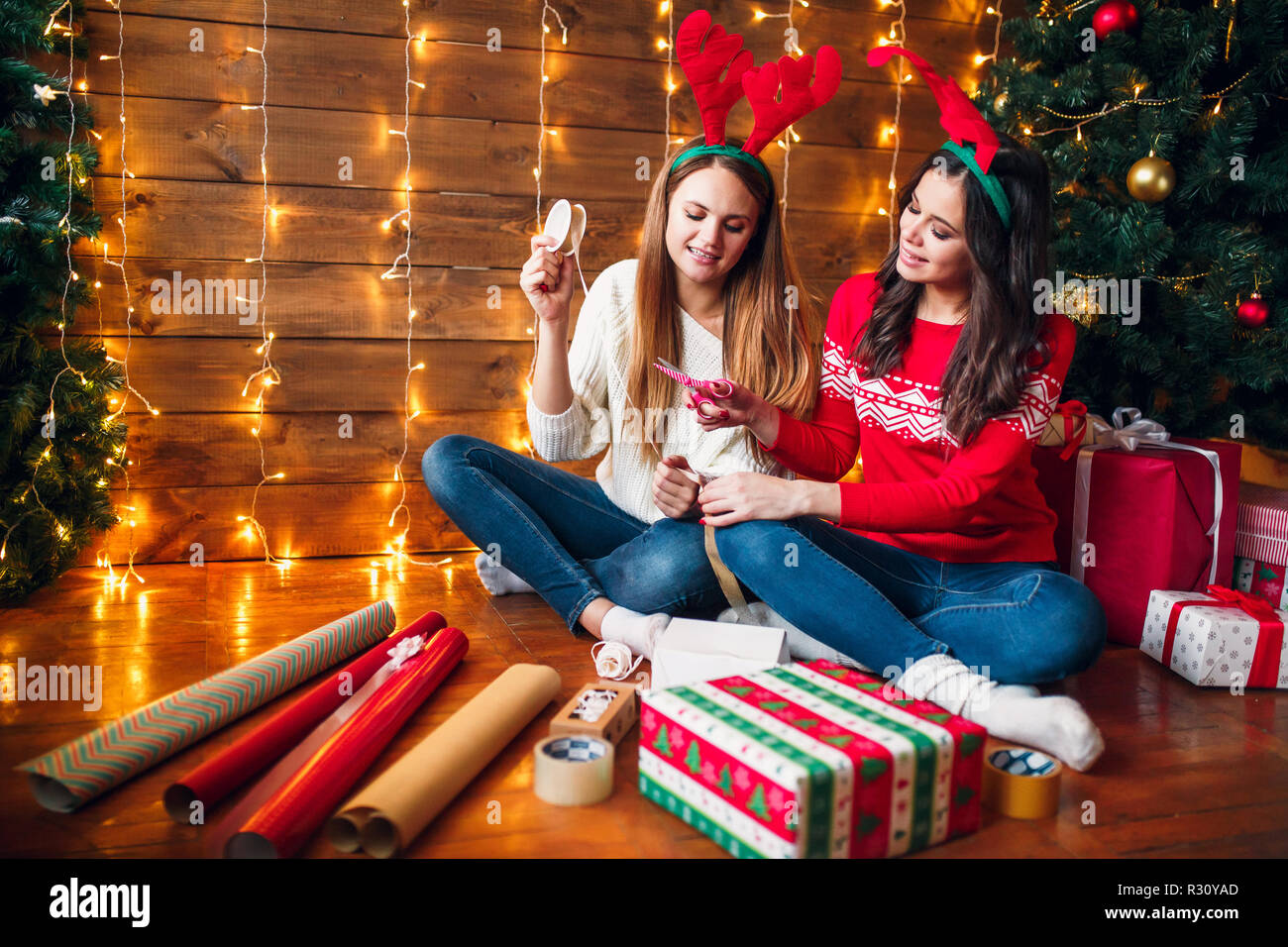 Sisters kneeling on floor and choosing christmas decorations Stock Photo