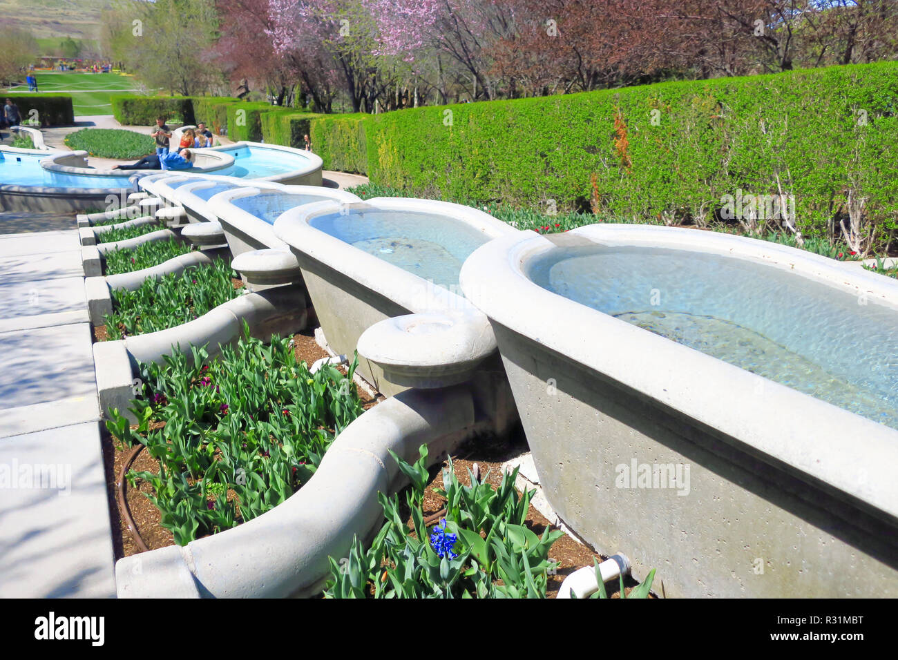 A row of decorative conrete baths flowing water down from an elevated position. Stock Photo