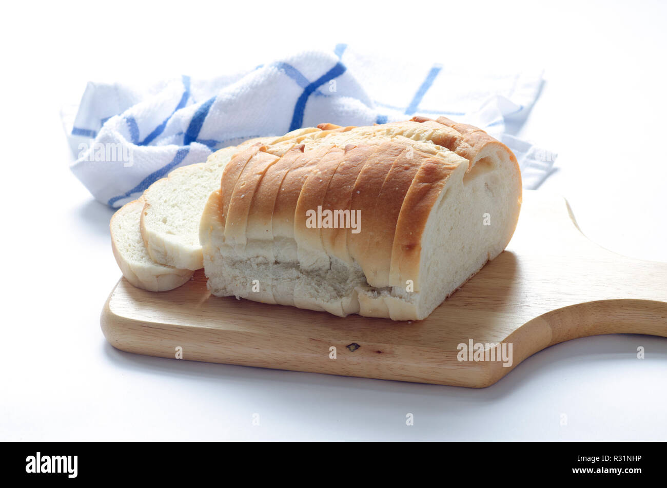 Loaf of sliced italian white bread on wood cutting board Stock Photo