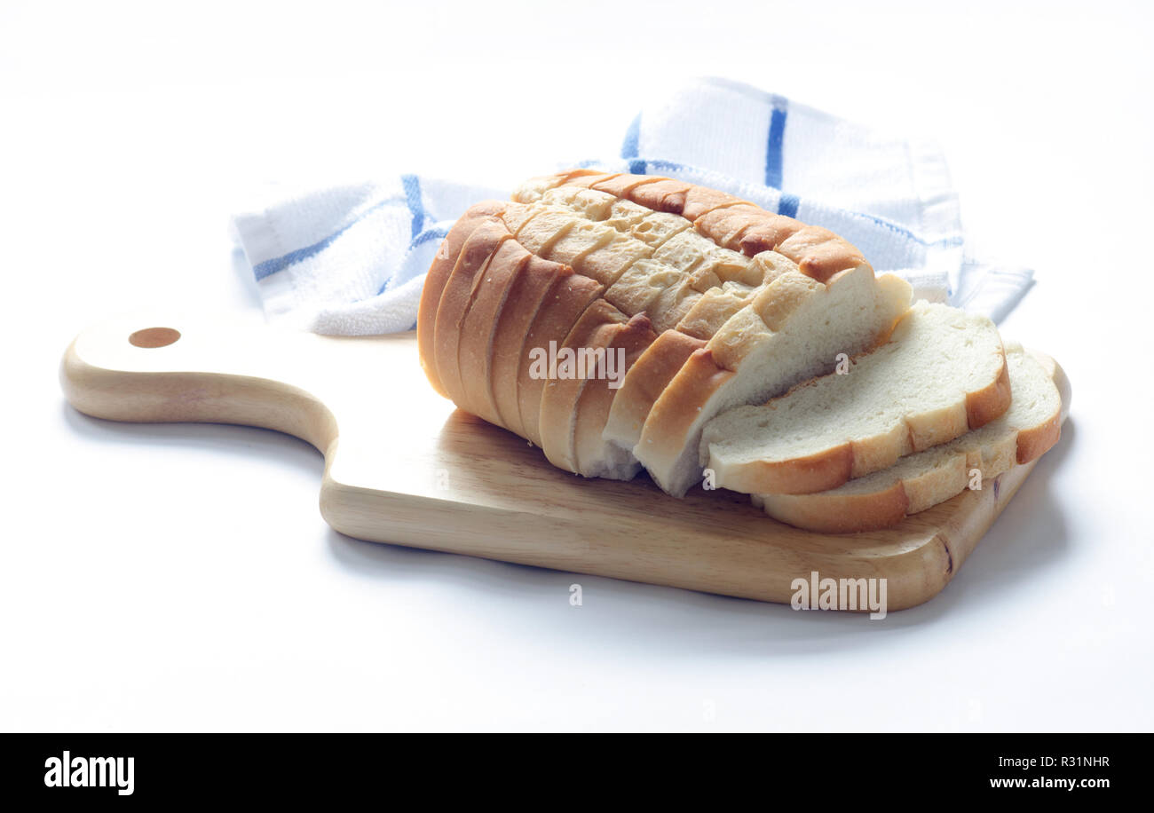 Loaf of sliced italian bread on wood cutting board with kitchen towel Stock Photo