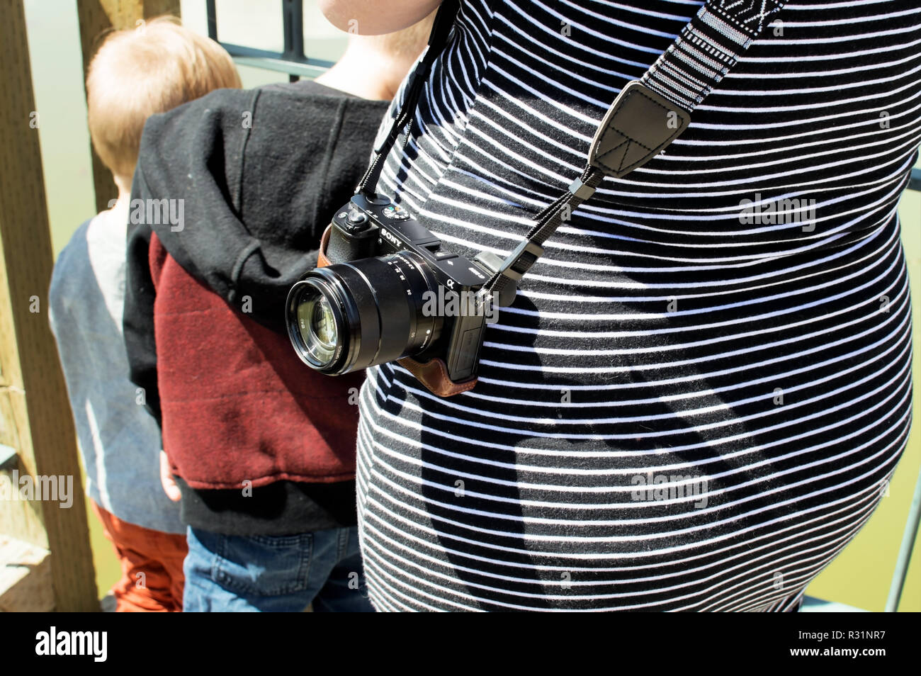 A sony a6500 in its leather case hanging on a womans hip. Stock Photo