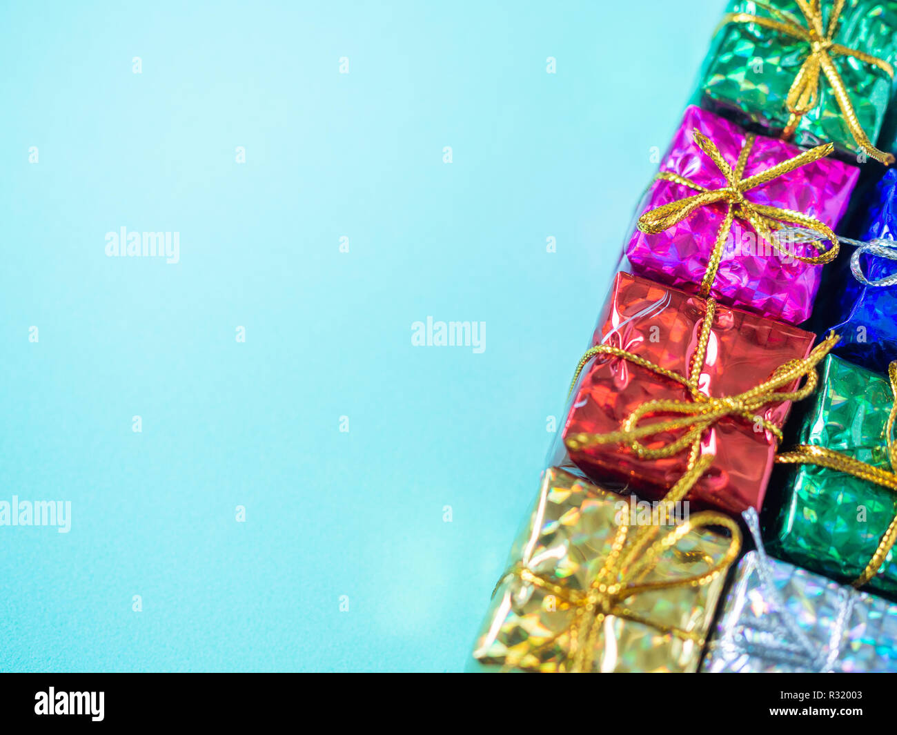 Small colorful gift boxes on light marine blue background with copy
