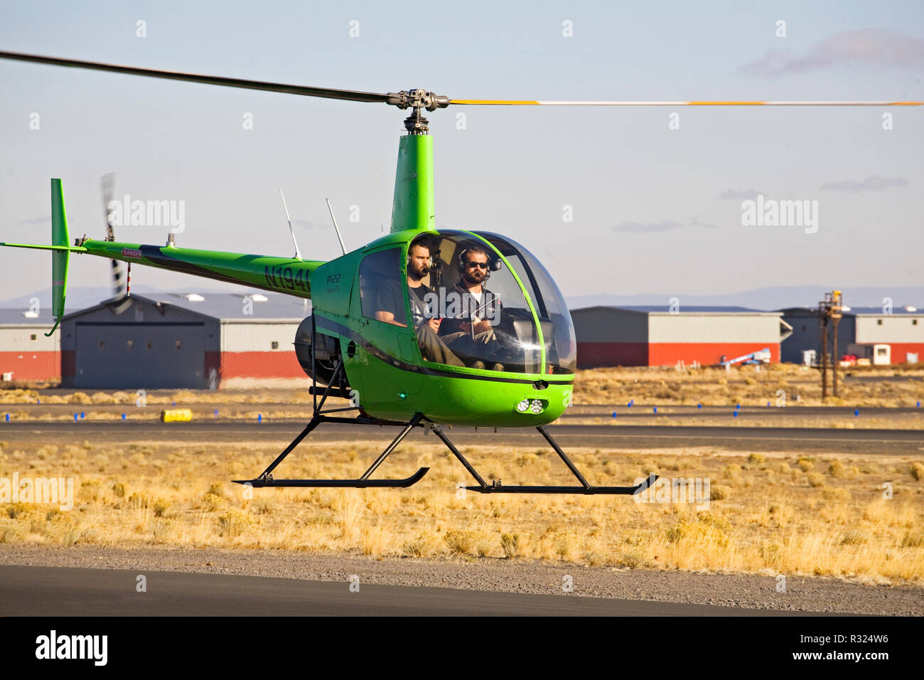 An instructor and student pilot fly a two-seat R22 Beta II helicopter made by the Robinson Helicopter Company, at a small city airport in Bend, Oregon Stock Photo