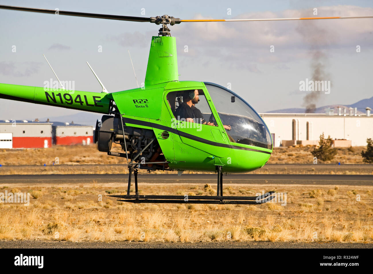 An instructor and student pilot fly a twoseat R22 Beta II helicopter