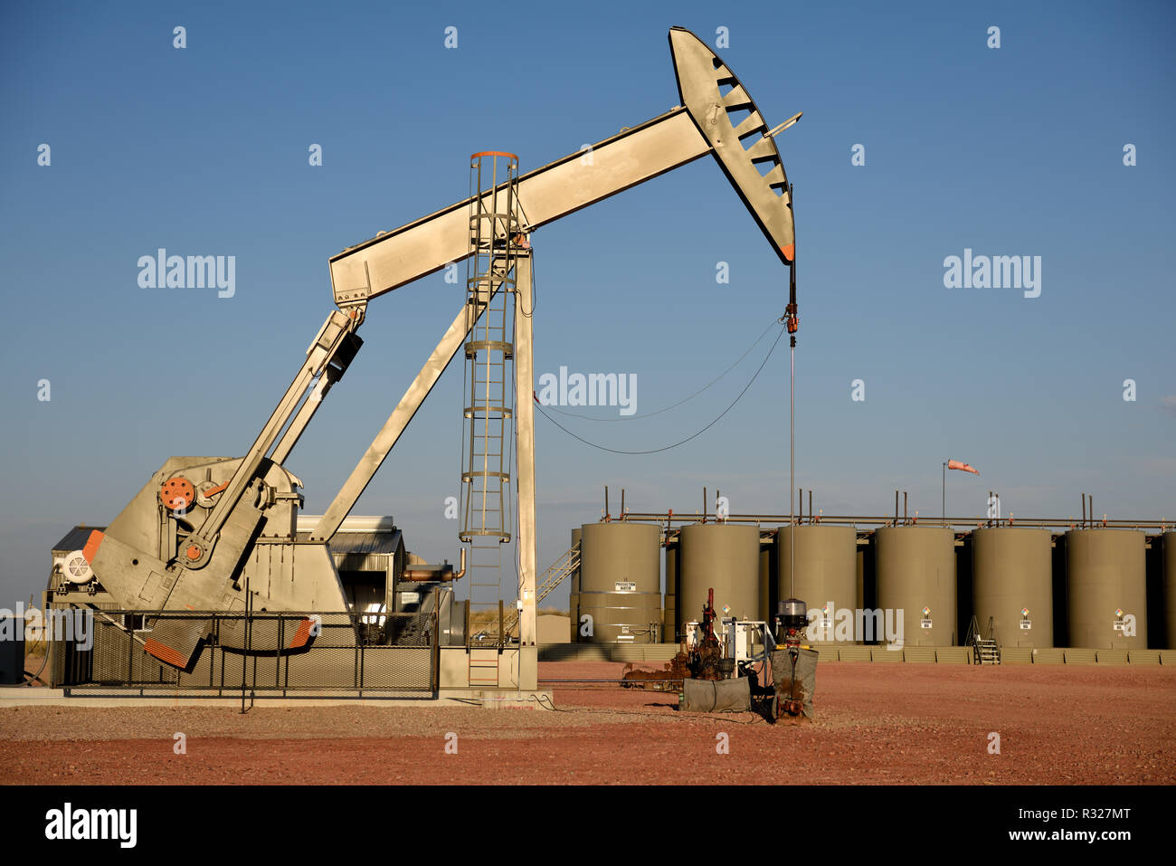 Crude oil pump jack and production storage tanks in the Powder River Basin. Stock Photo