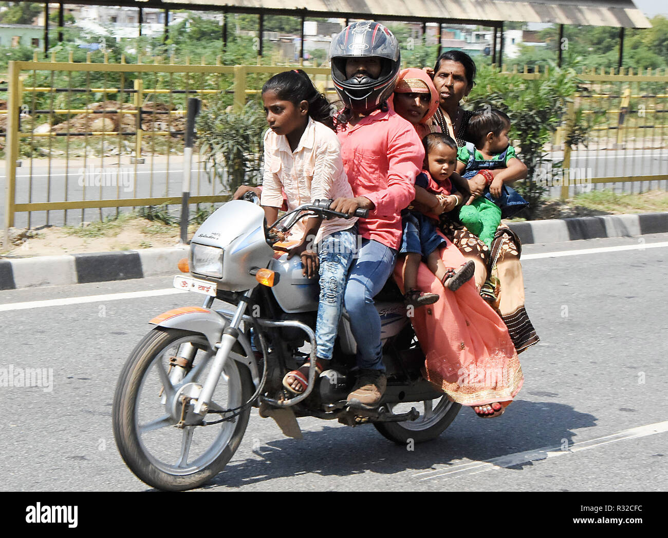 A family of six people, including two children on a crowded motorbike