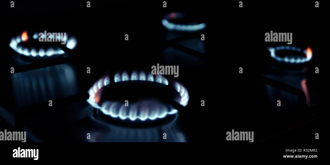 Gas kitchen stove cook with blue flames burning. Panel from steel with