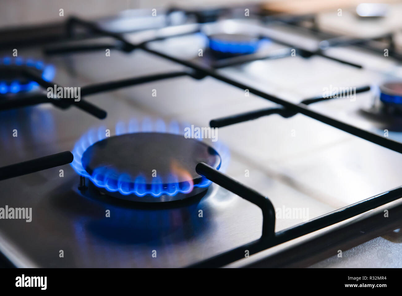 Gas kitchen stove cook with blue flames burning. Panel from steel with