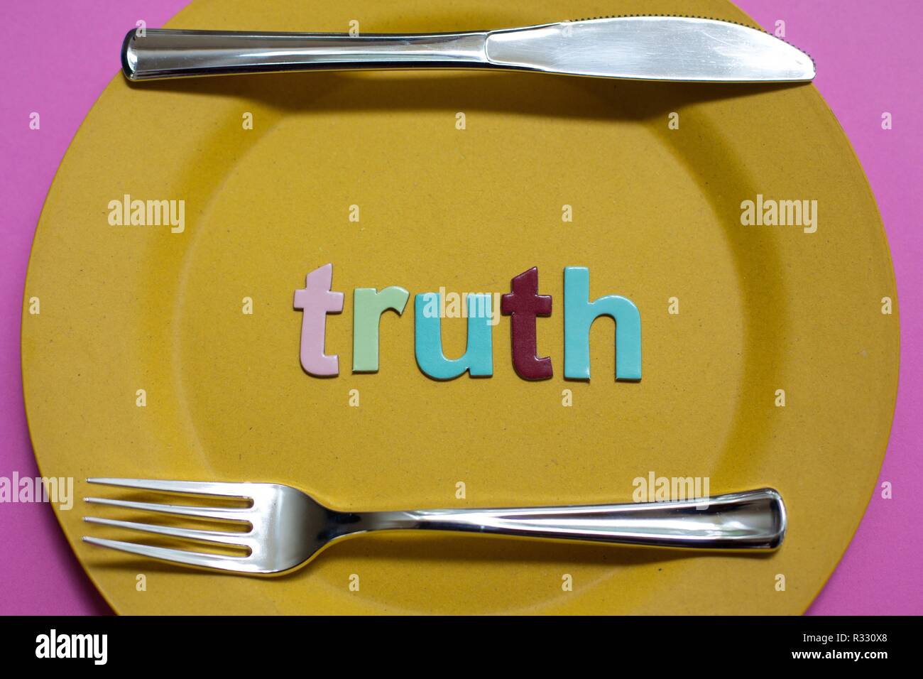 A plate with the word "truth", along with a fork and knife Stock Photo