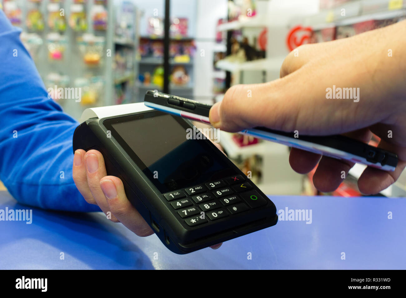 Mobile payments concept. Customer paying a merchant with mobile phone