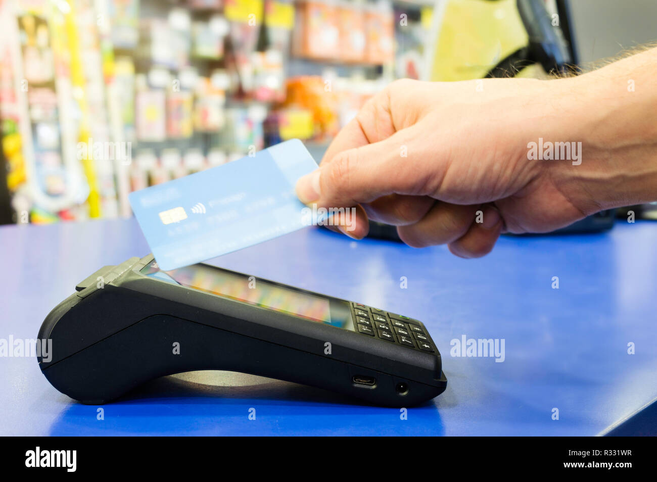 Mobile payments concept. Customer is paying using wireless or contactless credit card and payment terminal with NFC technology Stock Photo