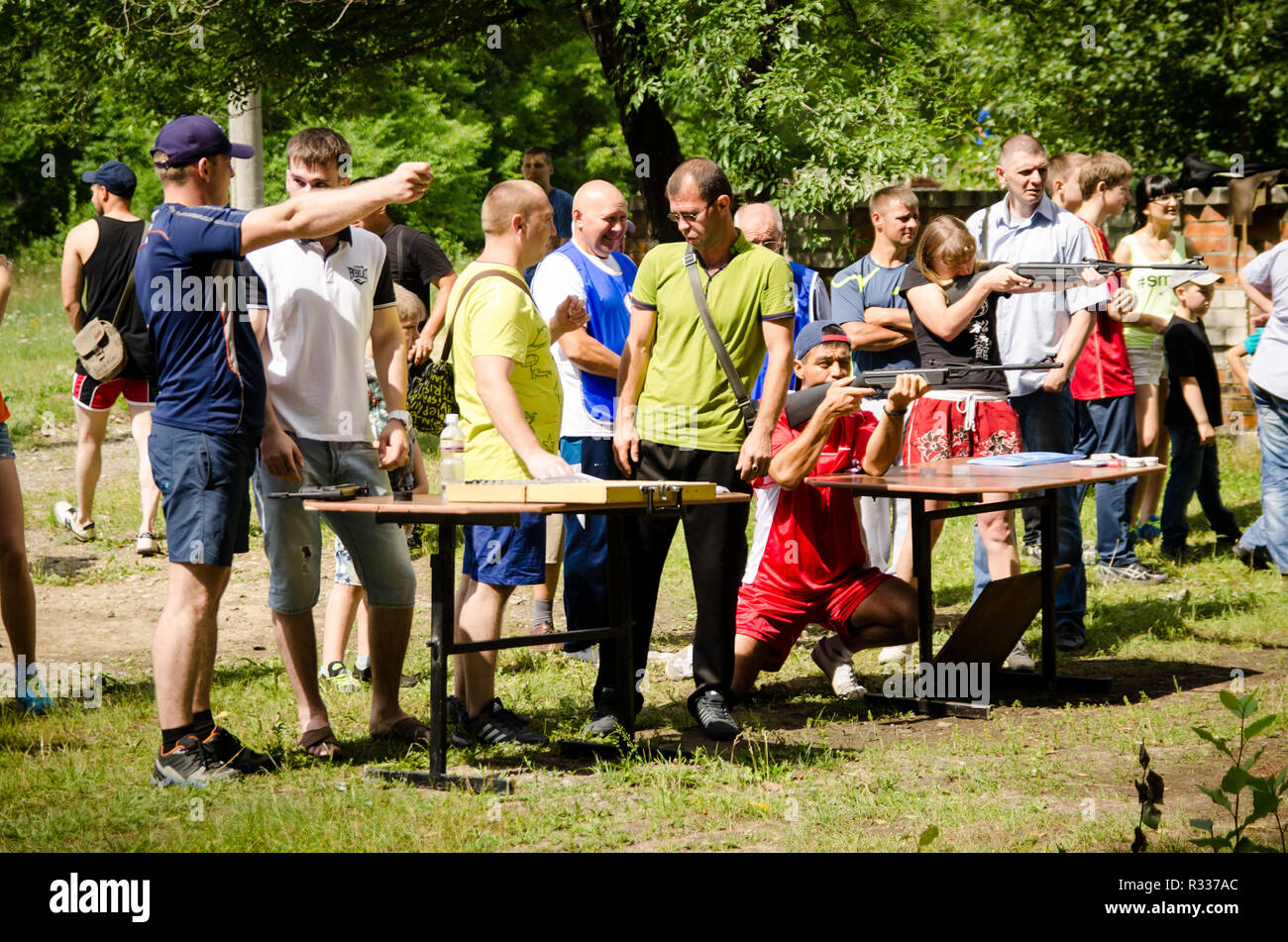 Komsomolsk-on-Amur, Russia - August 1, 2016. Public open Railroader's day. man shows his neighbor how to shoot sports pistol at amateur competitions Stock Photo