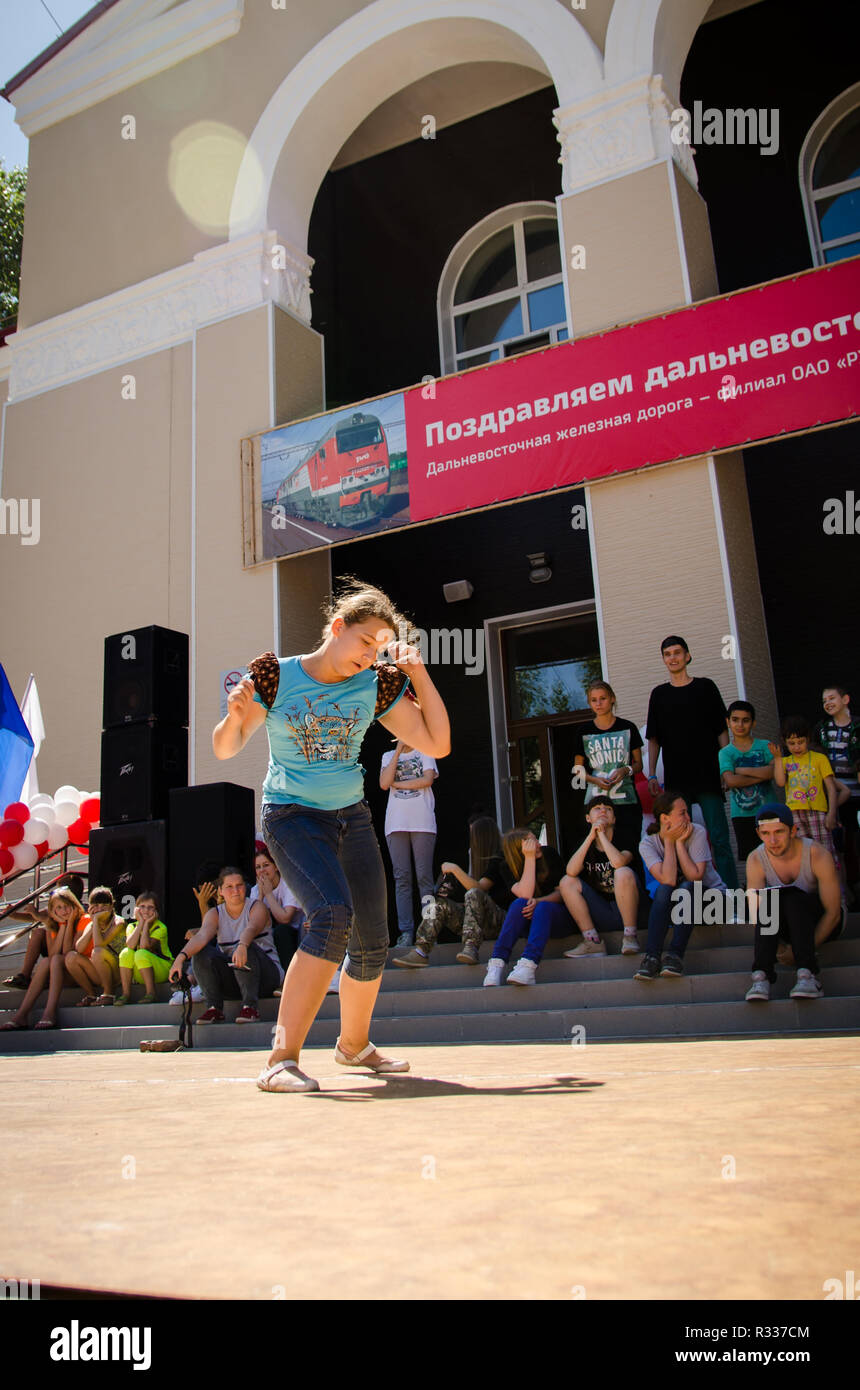 Komsomolsk-on-Amur, Russia - August 1, 2016. Public open Railroader's day. girl breakdancer dances breakdance in the square with spectators Stock Photo