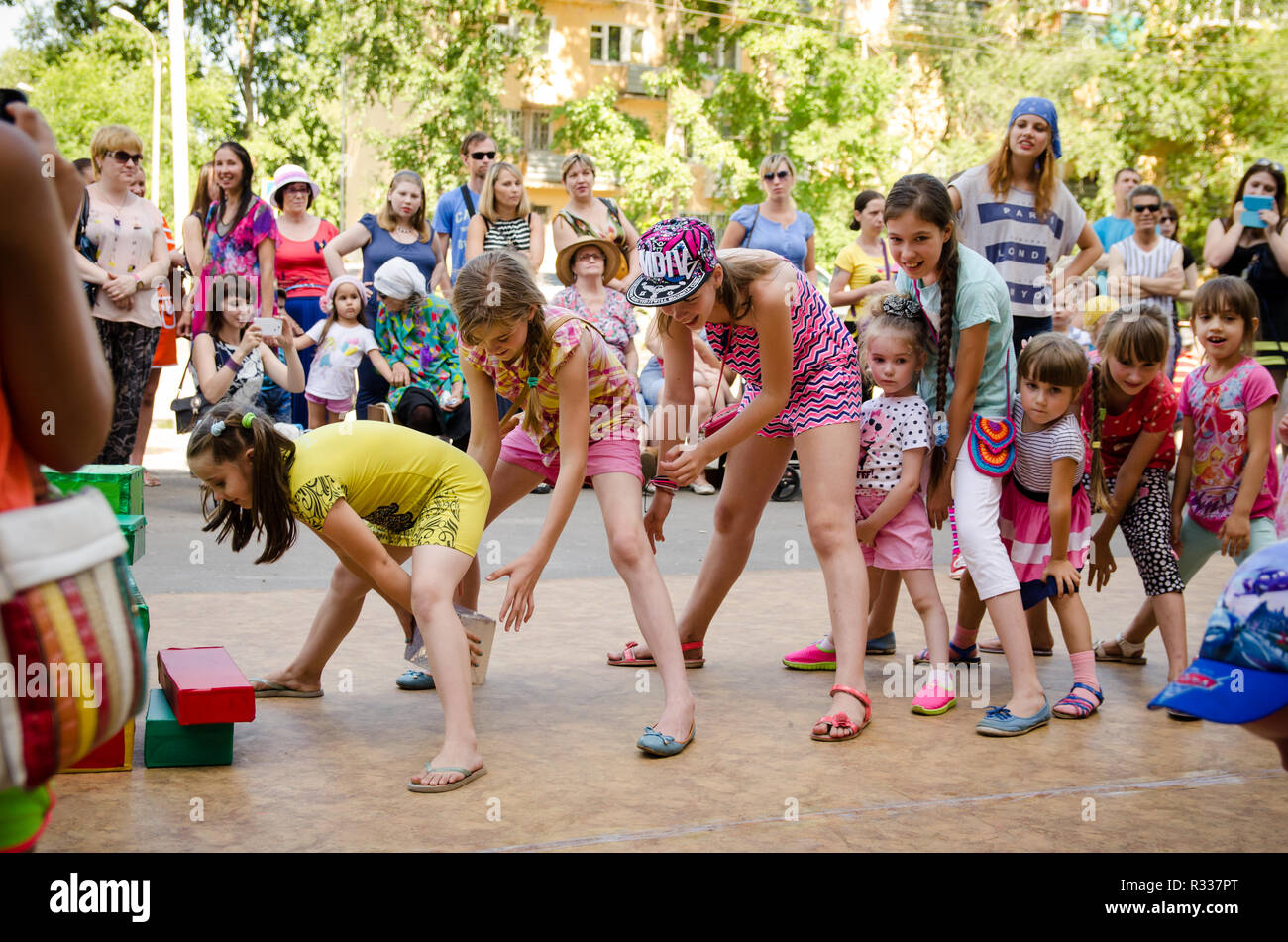 Komsomolsk-on-Amur, Russia - August 1, 2016. Public open Railroader's day. children playing fun game pass each other box between their legs at pirate  Stock Photo
