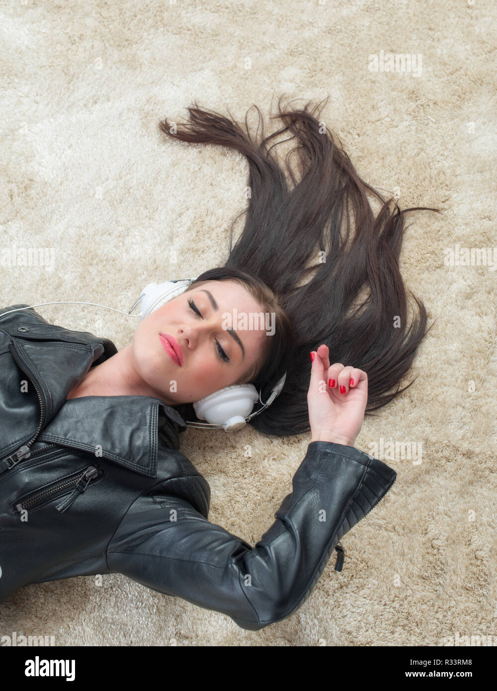 young woman lying on the floor and listening to music Stock Photo - Alamy