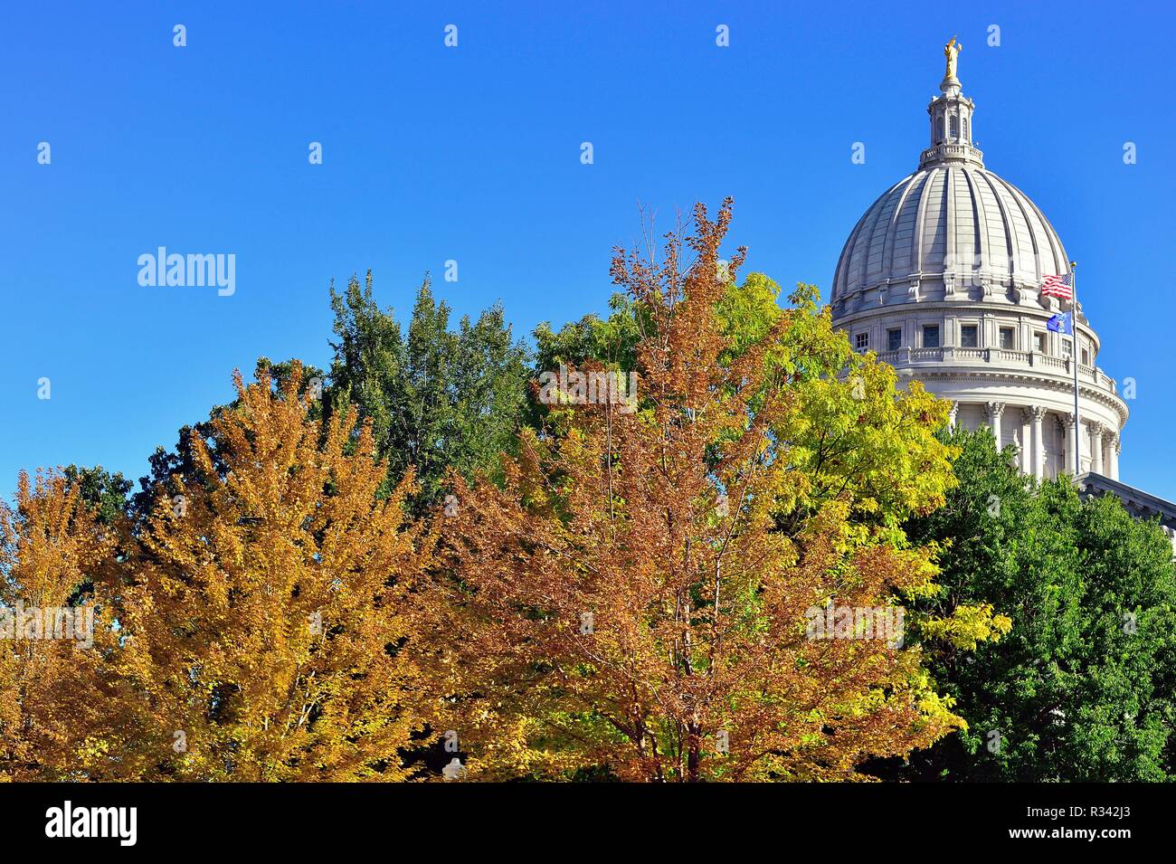 Madison, Wisconsin, USA. Evidence of fall surrounds the State Capitol Building dome featuring the the bronze 'Wisconsin' statue on top. Stock Photo