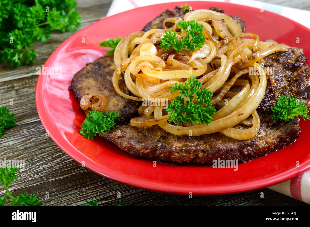 Juicy slices of fried liver and onions on a red plate Stock Photo Alamy