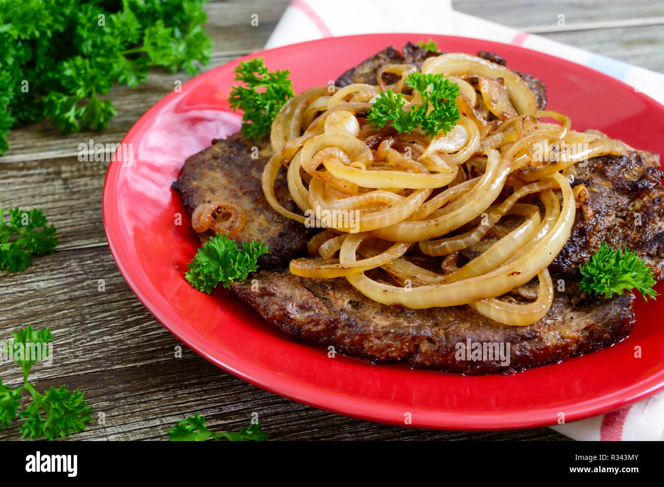 Juicy slices of fried liver and onions on a red plate Stock Photo Alamy