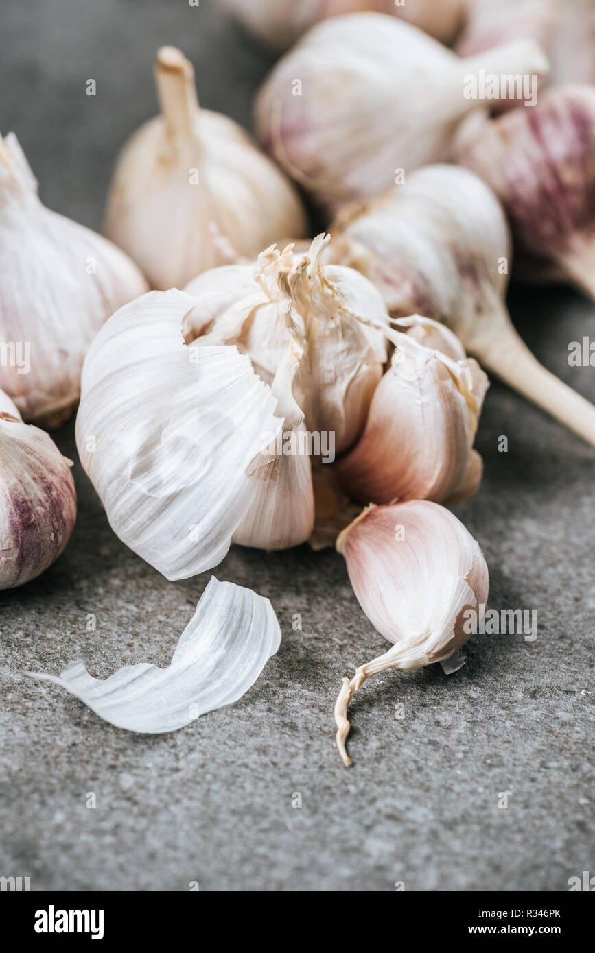 garlic bulbs and peeled cloves on grey textured surface Stock Photo - Alamy
