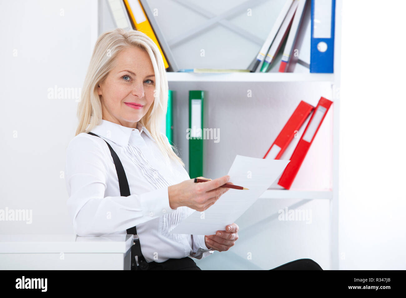 Happy business woman working in office with documents. Woman reading ...